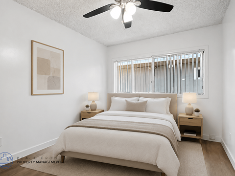 A bedroom with a large bed and a ceiling fan.