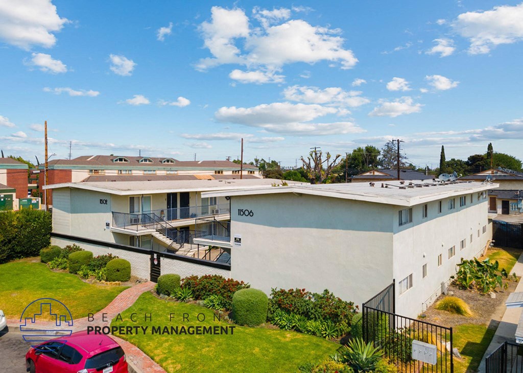 a large white building with a red car parked in front of it