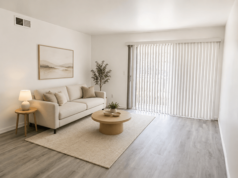 A living room with a couch, a small table, and a painting on the wall.