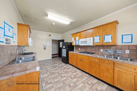 A kitchen with wooden cabinets and a tile floor.