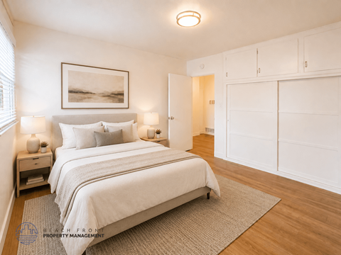 A bedroom with a large bed and a painting on the wall.