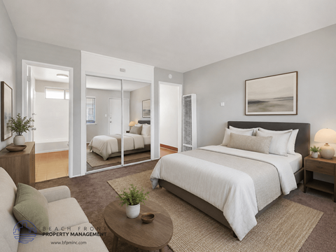 A bedroom with a large bed, a couch, and a coffee table.