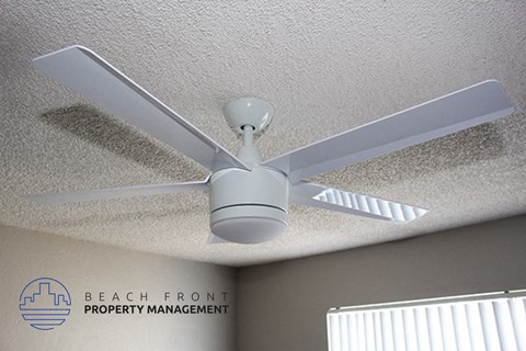 a white ceiling fan hanging from the ceiling of a room