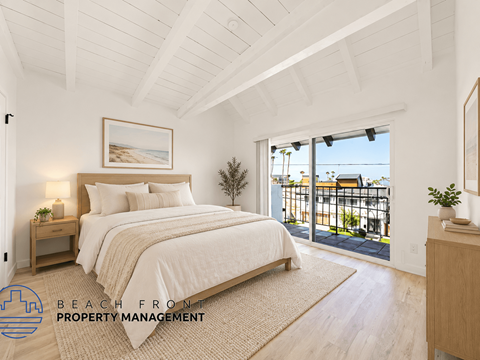 A bedroom with a large bed and a balcony overlooking the beach.