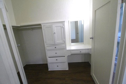 a small room with a white dresser and a mirror
