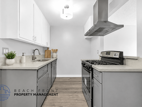 A kitchen with a stove top oven and a range hood.