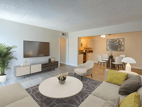 A living room with a white coffee table and grey couches.