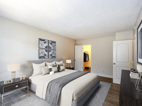 A bedroom with a large bed and a painting on the wall.