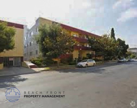 A street view with a car parked and a building with the text "BEACH FRONT PROPERTY MANAGEMENT".