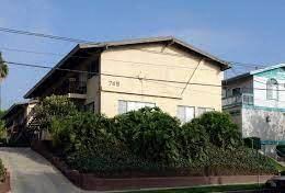 a yellow house with a hedge in front of it