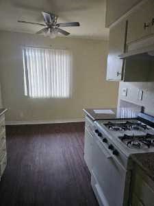 a kitchen with a stove and a ceiling fan