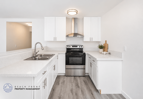 A kitchen with white cabinets and a stainless steel oven.