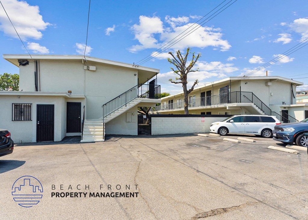 a beach front property management building with cars parked in front of it