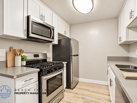 A kitchen with a stove, microwave, and refrigerator.