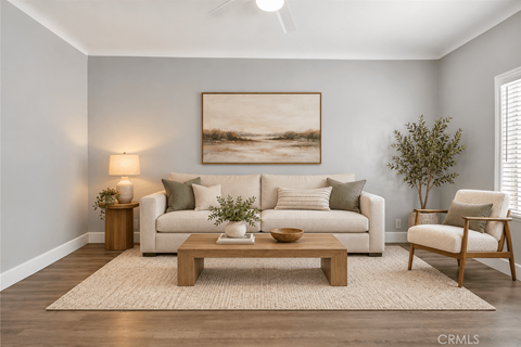 A living room with a white couch, a wooden coffee table, and a painting on the wall.
