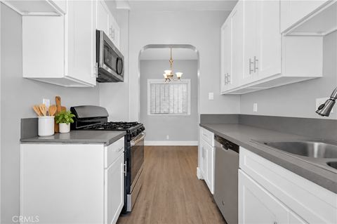 A kitchen with white cabinets and a black stove top.