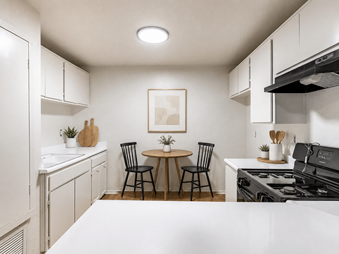A kitchen with a table and chairs in the middle.