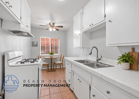 A kitchen with white cabinets and a tiled floor.