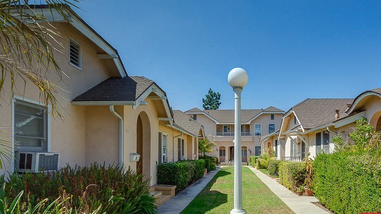 a row of houses on the side of a sidewalk