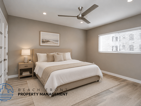 A bedroom with a bed, nightstand, and a ceiling fan.