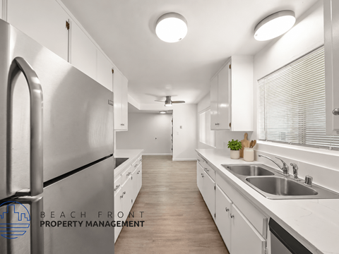 A modern kitchen with stainless steel appliances and white cabinetry.