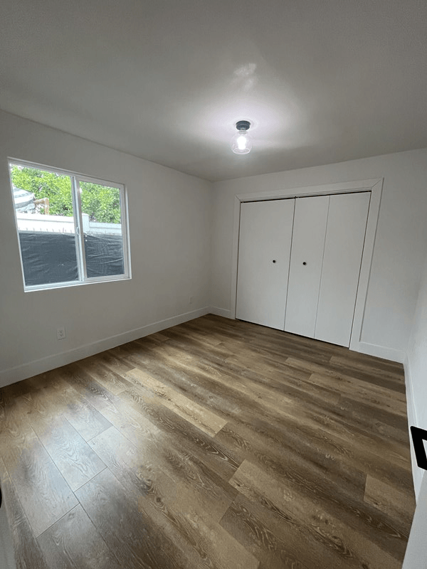 an empty room with a large window and white walls