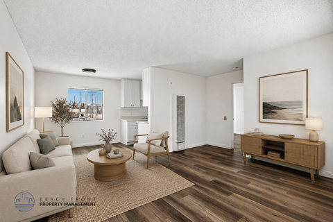 A living room with a couch, coffee table, and a painting on the wall.