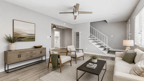 A living room with a white couch, a wooden chair, a coffee table, and a painting on the wall.