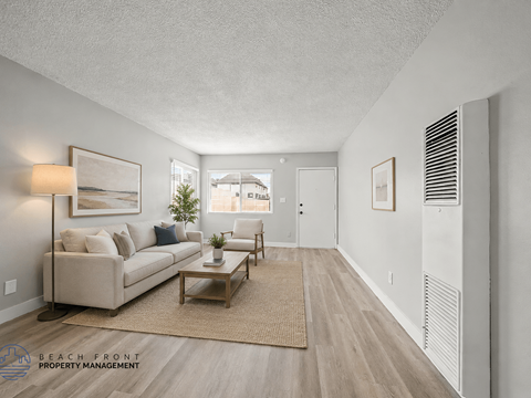 A living room with a couch, coffee table, and a window.