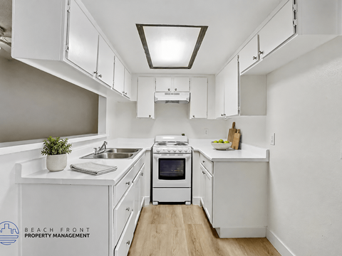A kitchen with white cabinets and a stove top oven.