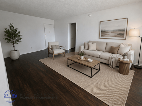 A living room with a white couch, a coffee table, and a painting on the wall.