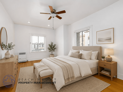A well-lit bedroom with a large bed and a ceiling fan.