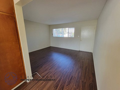 the living room of a house with wood flooring and a window