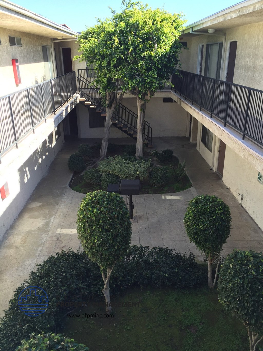 an aerial view of a courtyard with trees and bushes