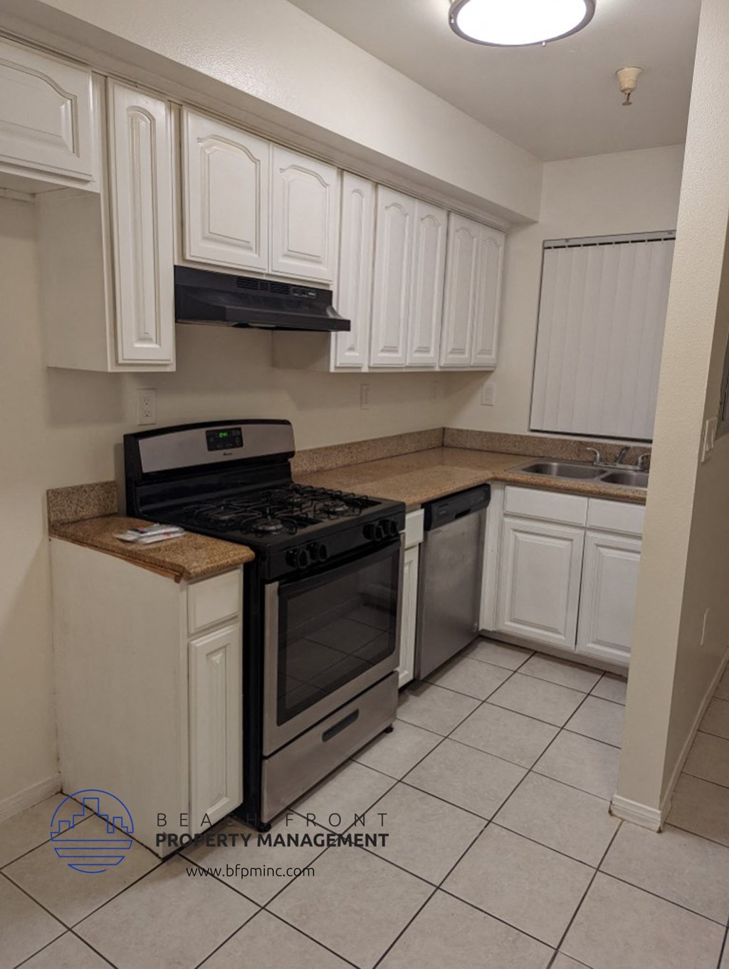 a kitchen with white cabinets and a stove and a sink