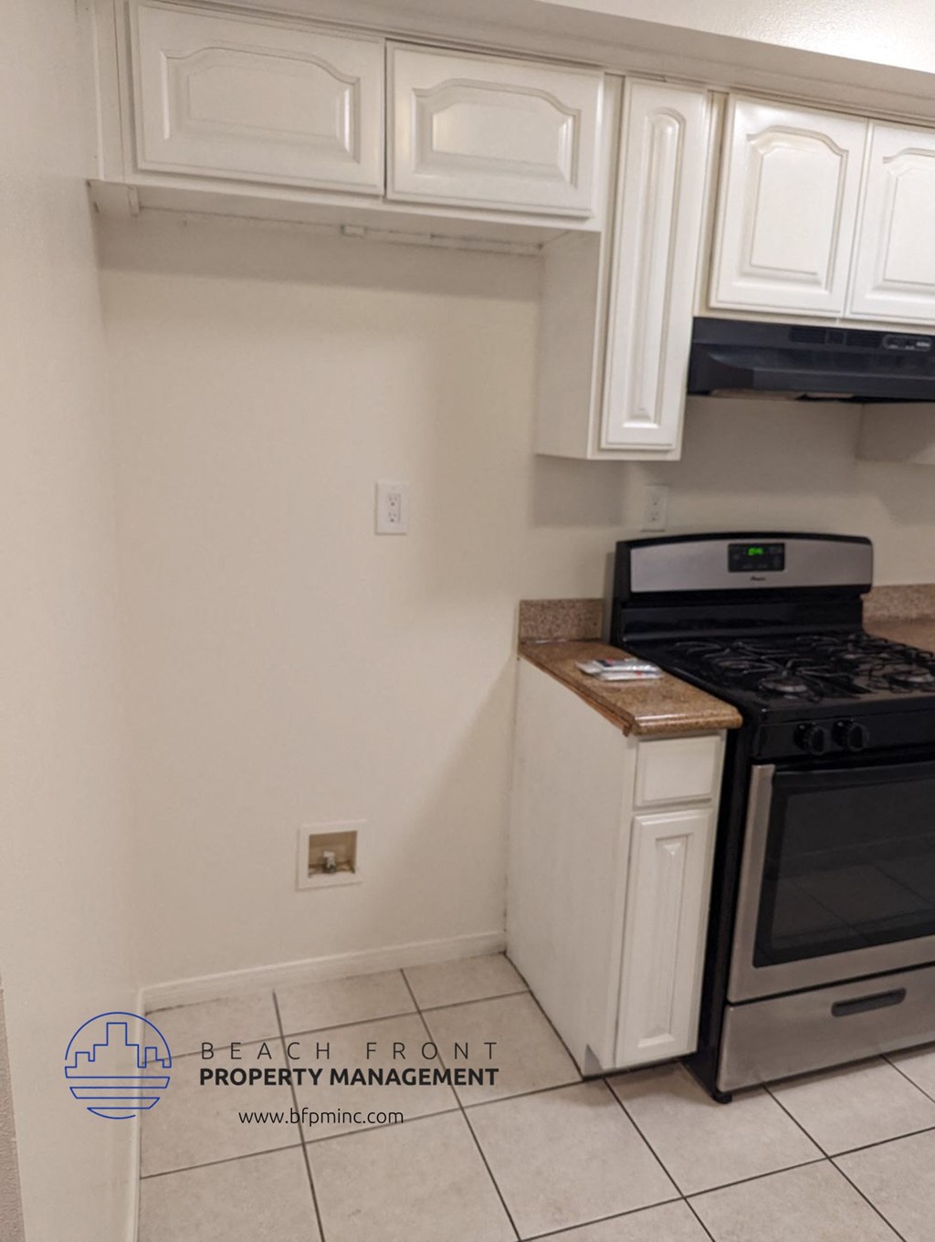 a kitchen with white cabinets and a stove and a refrigerator
