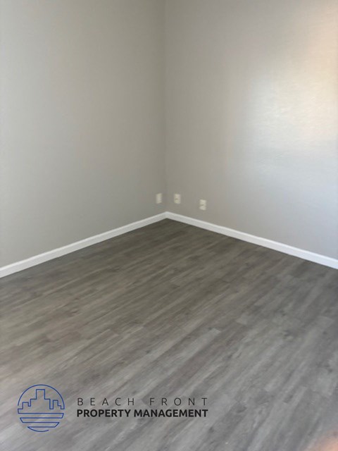 an empty room with wood floors and white walls