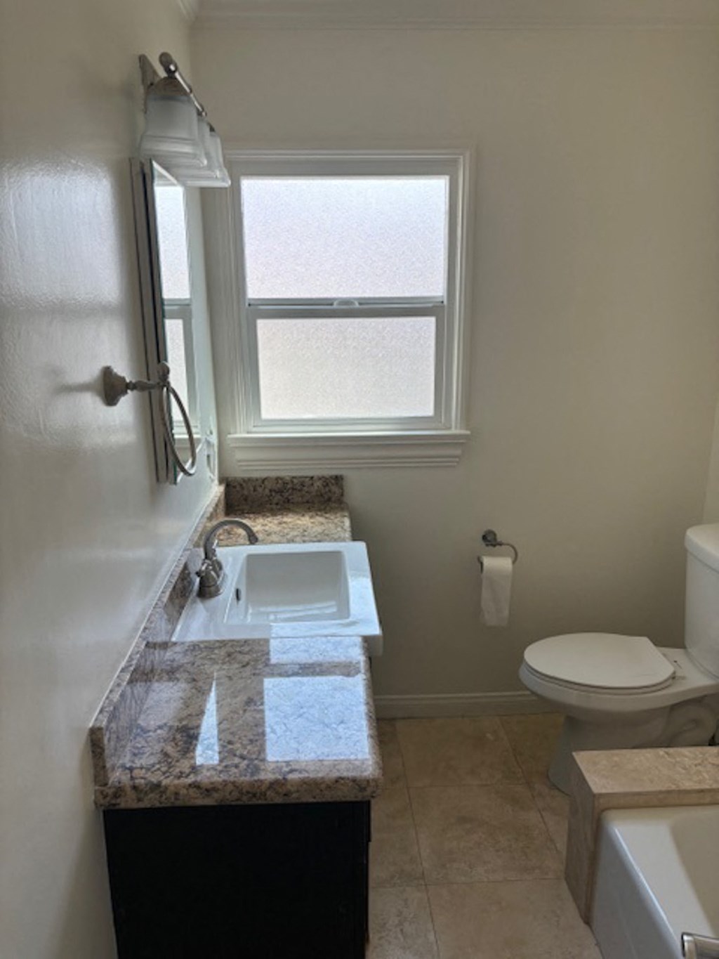 a bathroom with a sink and a toilet and a window