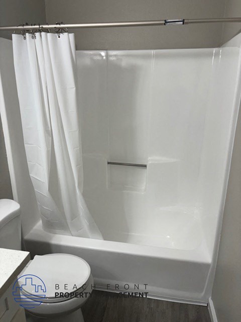 a bathroom with a shower and a toilet and a shower curtain