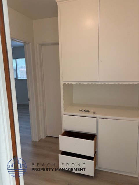 A white kitchen with a counter and drawers.