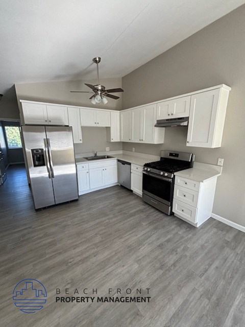 a white kitchen with stainless steel appliances and white cabinets
