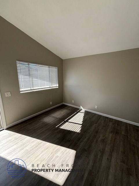 an empty room with wooden floors and a window