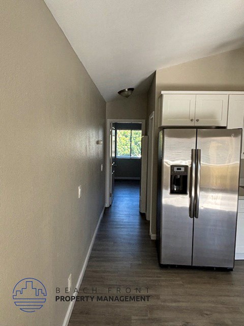 a kitchen with a stainless steel refrigerator and white cabinets