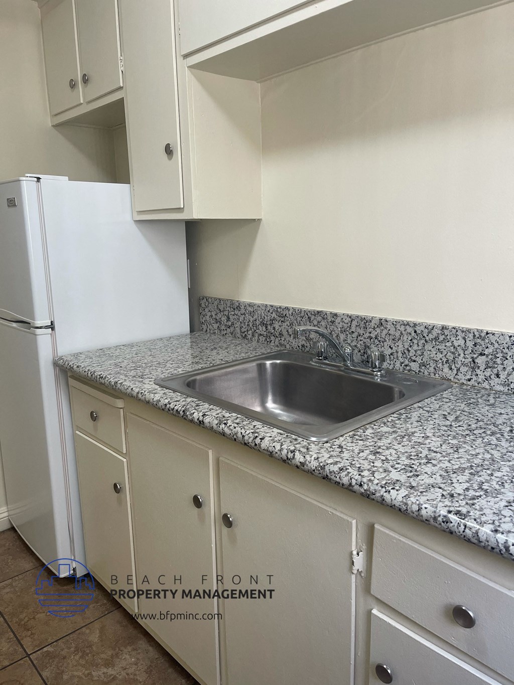 a kitchen with white cabinets and granite counter tops and a sink