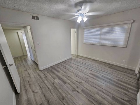 an empty room with a ceiling fan and a window