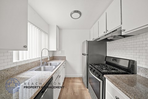 A kitchen with a stove top oven and a sink.