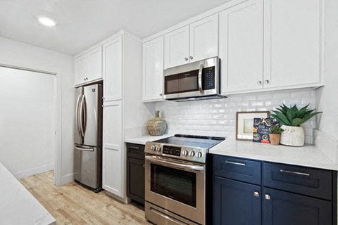 A kitchen with a stove top oven and a refrigerator.