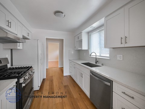 A kitchen with white cabinets and a black stove top oven.