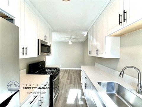 a kitchen with white cabinets and a sink and a microwave