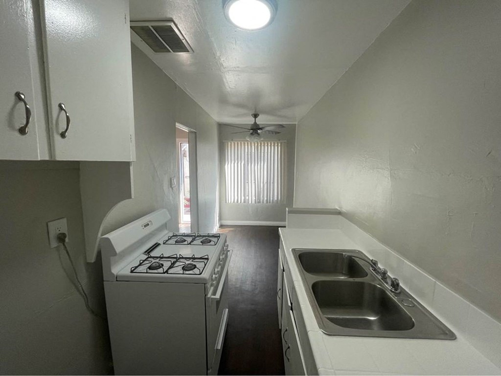 an empty kitchen with a stove and a sink